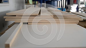 Material for the manufacture of furniture parts. A stack of white MDF panels lies on the floor. Material for the