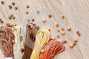Materials for bracelets - beads and yarn on wooden table. Colorful photography with copy space for text. Selected focus