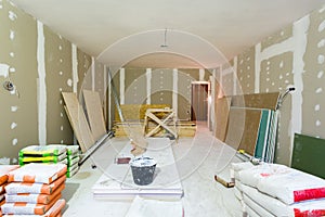 Materials for construction putty packs, sheets of plasterboard or drywall in apartment is under construction, remodeling
