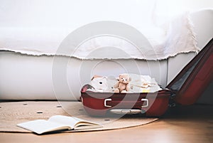 Maternity bag for hospital and paper diary with checking list at home interior. Suitcase of baby clothes and necessities preparing photo
