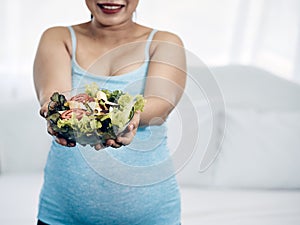 Maternity in Comfort: Asian Woman Eating Nutritious slad in Homely Bedroom