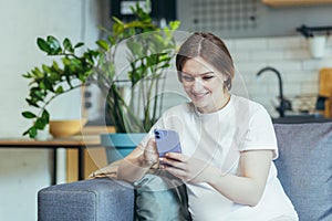 Mateřství odejít. krásná žena na gauč na držení mobilní telefon v rodič chatování 