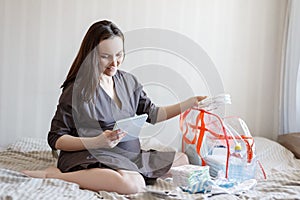 Maternity leave. A young pregnant woman collects a bag through the list
