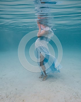 Maternity shoot underwater with young pregnant lady.
