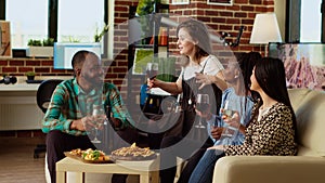 Mates having lively conversation, throwing party in modern apartment living room