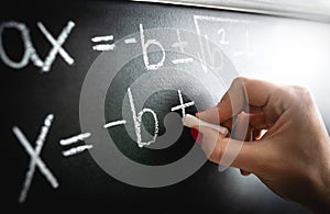 Math equation, function or calculation on chalkboard. Teacher writing on blackboard during lesson and lecture in school.