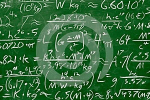 Math equations and formula written in chalk on green chalkboard background. School or scientific research concept