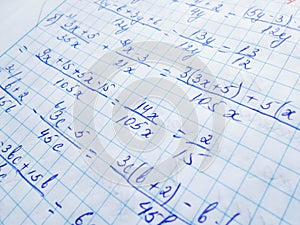 Math formulas are written in a notebook with a pen. The solution of examples and problems in a notebook