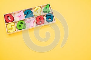 Math game for junior age with colored wooden signs of numbers