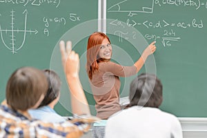 Math student write on green chalkboard classmates photo