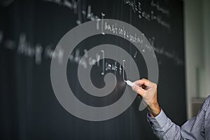 Math teacher by the blackboard during mathclass