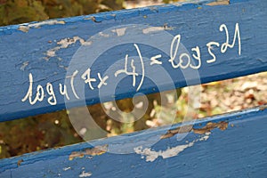 Mathematical equation written on a wooden park bench