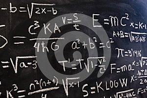 Mathematical equations and physics formulas handwritten on blackboard