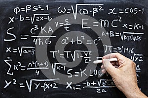 Mathematical equations and physics formulas handwritten on blackboard