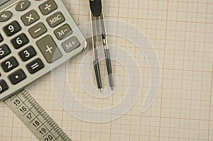 Mathematical instruments lie on a graph paper with copy space for text. Math graphic tools concept