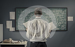 Mathematician studying math formulas on the chalkboard