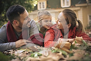 Mather and father with little girl laying on ground, at front of