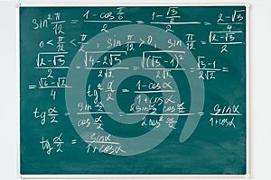 Maths formulas written by white chalk on the blackboard.