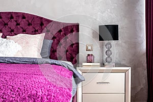 Matrimonial double bed in elegant and comfortable modern bedroom with nightstand lamp closeup