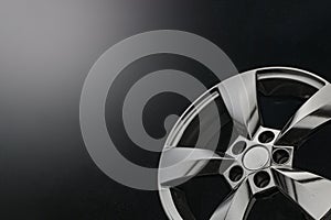 Matte black alloy wheels on a dark background. concept for car shops and service stations, copy space