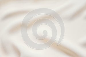 Matte cream soft pleated fabric background. Smooth elegant luxury cloth texture. Gentle pastel color wedding background