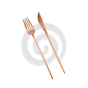 Matte pink golden or copper color fork and knife isolated on white background. Cutlery set in trendy color of 2024 Peach Fuzz