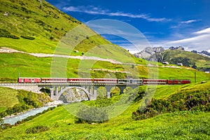 The Matterhorn - Gotthard - Bahn train on the viaduct bridge near Andermatt in Swiss Alps