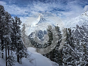 Matterhorn mountain in front of a blue sky with clouds in Zermatt, Switzerland.