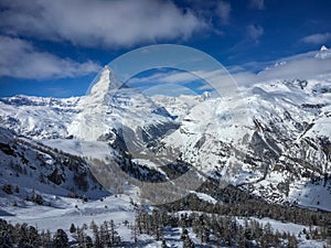 Matterhorn mountain in front of a blue sky with clouds in Zermatt, Switzerland.