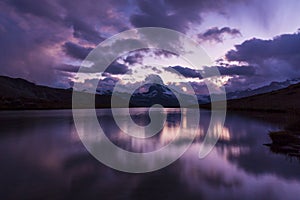 Matterhorn peak at sunrise, with reflection in a lake, in summer