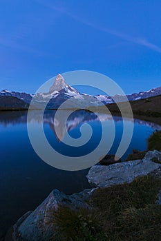 Matterhorn peak at sunrise, with reflection in a lake, in summer