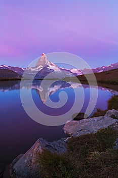 Matterhorn peak at sunrise, with reflection in a lake, in summer