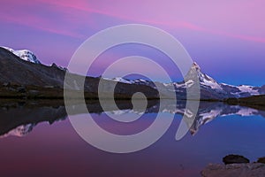 Matterhorn peak at sunrise, with reflection in a lake, in summer