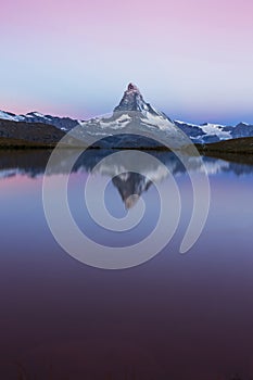 Matterhorn peak at sunrise, with reflection in a lake, in summer