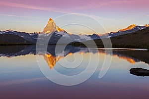 Matterhorn peak at sunrise, with reflection in a lake, in summer