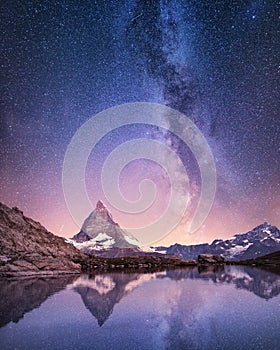 Matterhorn and reflection on the water surface at the night time. Milky way above Matterhorn, Switzerland.