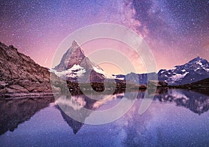 Matterhorn and reflection on the water surface at the night time. Milky way above Matterhorn, Switzerland.