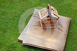 Mattress and basket with massage accessories on a green lawn. The concept of rest, relaxation in nature, on vacation