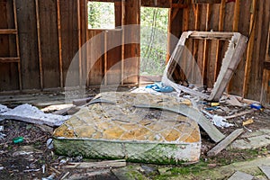 Mattress and broken bed frame in an abandoned shack