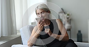 Mature 45s woman holds cellphone talks on speakerphone