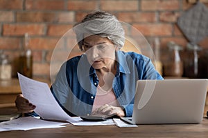 Mature 60s woman manage household finances at home