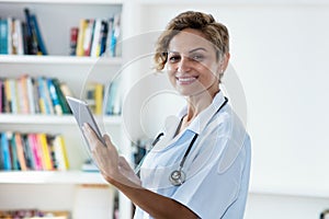 Mature adult female scientist with tablet computer researching for vaccine against coronavirus