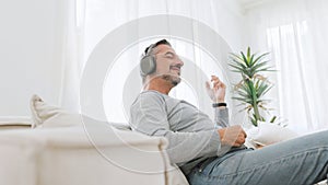 Mature adult man in headphones playing air guitar
