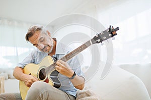 Mature Adult Man playing acoustic guitar