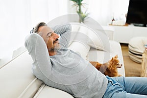 Mature Adult man relaxing and resting with chihuahua dog