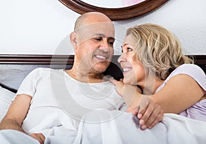 Mature adults lying in family bed