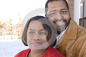 Mature African American couple laughing and hugging.