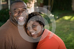 Mature African American couple laughing and hugging.