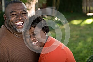 Mature African American couple laughing and hugging. photo