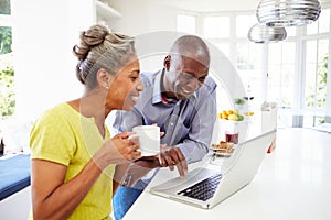 Mature African American Couple Using Laptop At Bre